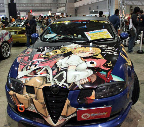 『魔法少女まどかマギカ』の巴マミとお菓子の魔女・シャルロッテ。車種はアルファロメオ。