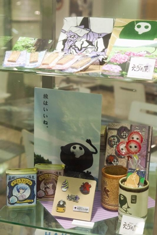キャンディやピンズ、湯のみなどのグッズが展示されている。